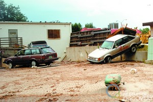 Flood-damaged cars at the back of retail shops along College Avenue